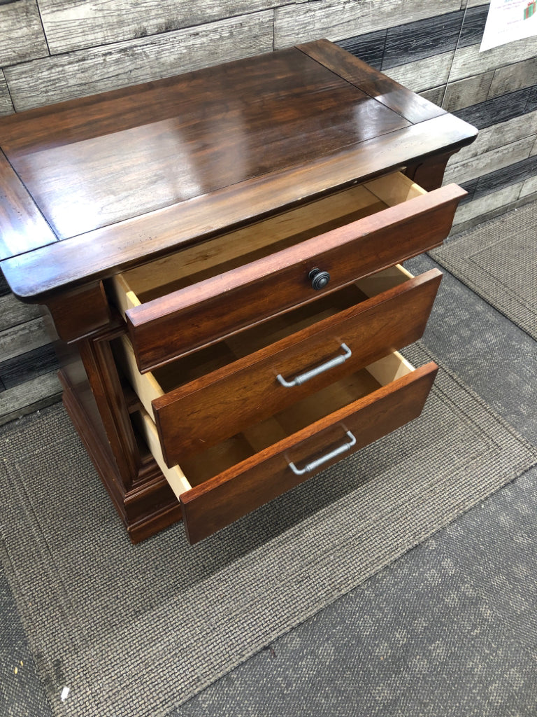 DARK CHERRY SIDE TABLE W/VTG METAL HANDLES & GLASS COVER ON WHEELS.