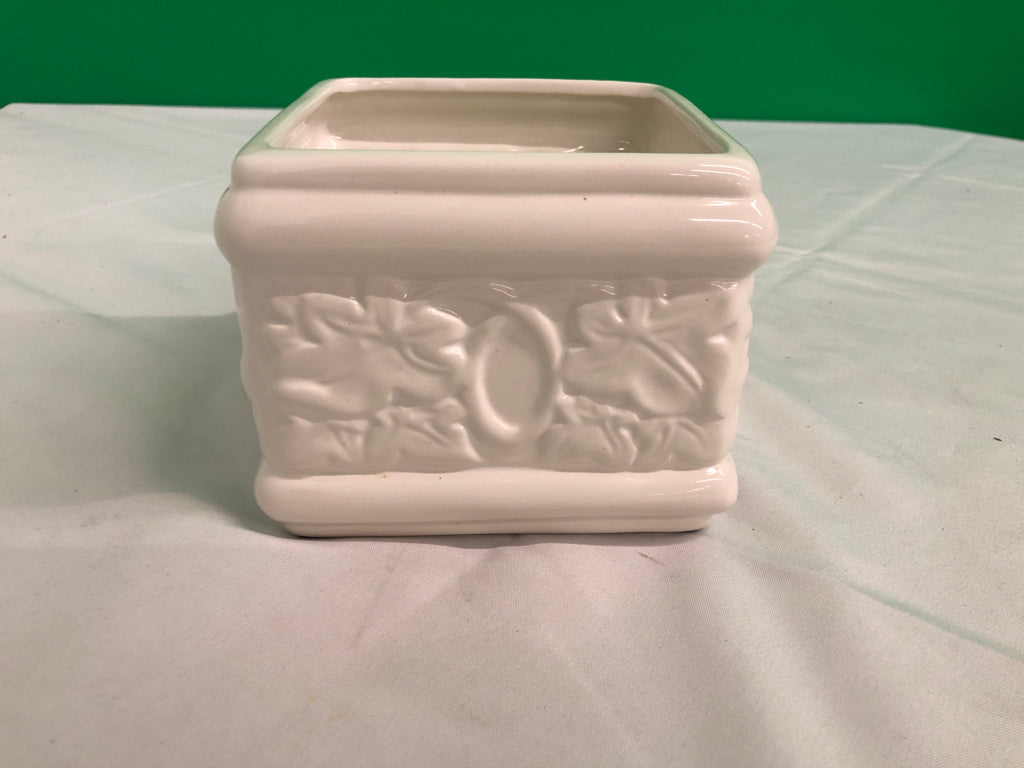 WHITE SQUARE CERAMIC PLANTER W/ EMBOSSED FLOWERS.