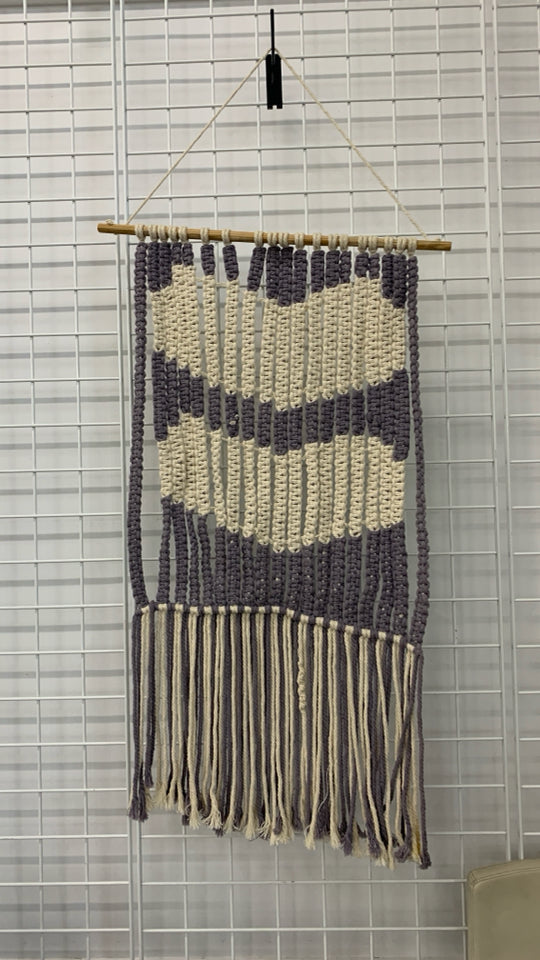 CREAM AND PURPLE MACRAME WALL HANGING ON DOWEL ROD.