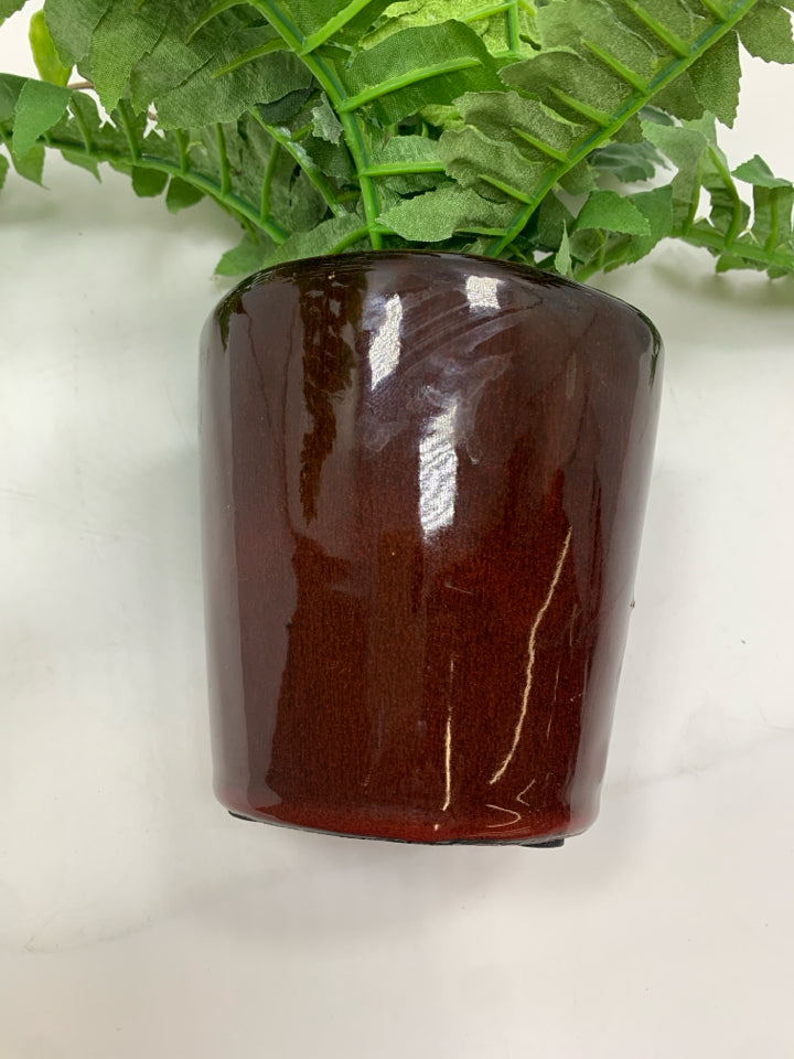 FAUX FERN IN BROWN CERAMIC POT.