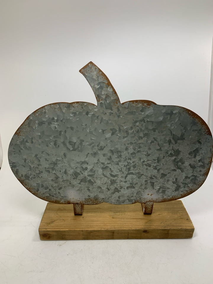 LARGE GALVANIZED PUMPKIN ON WOOD BOARD.