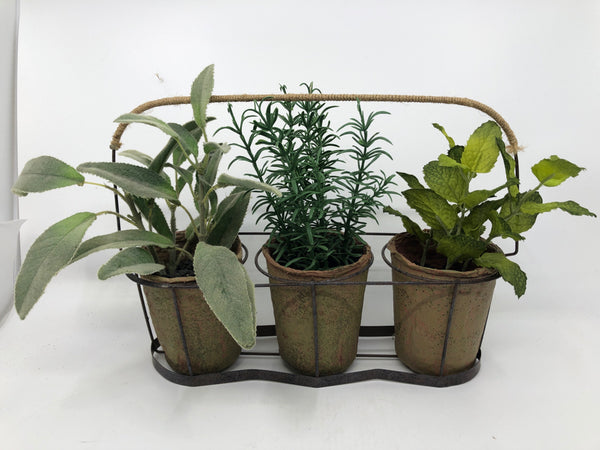 3 FAUX PLANTS IN BROWN METAL HOLDER.