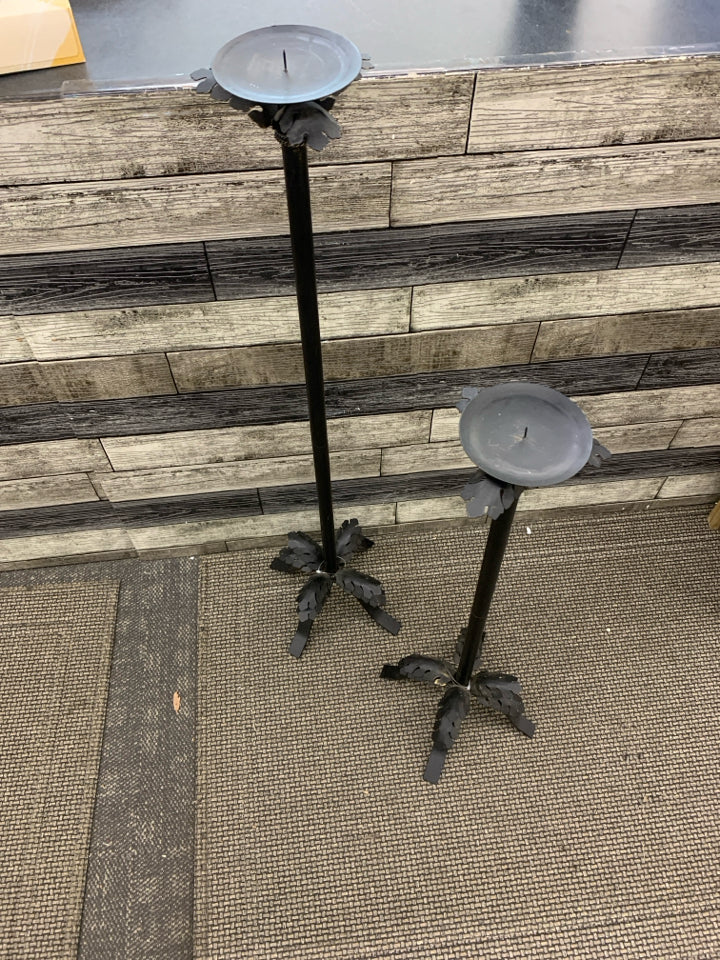 2 BLACK METAL FOOTED PILLAR CANDLE HOLDERS W/ LEAVES.