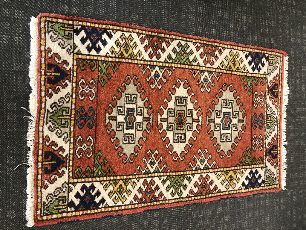ORANGE ORIENTAL PATTERN RUG W/WHITE FRINGE.