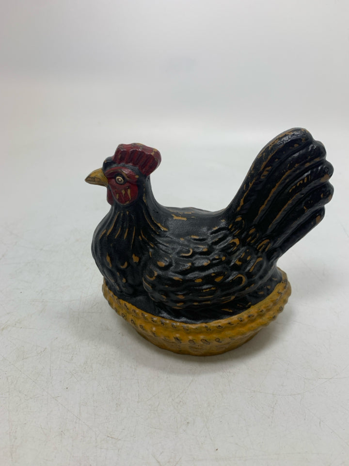 BLACK DISTRESSED HEN SITTING IN NEST.