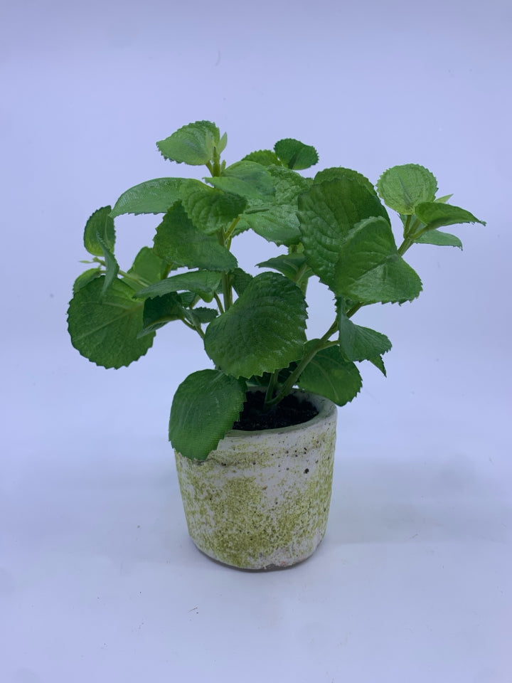 FAUX GREENS IN WHITE CEMENT STYLE PLANTER.