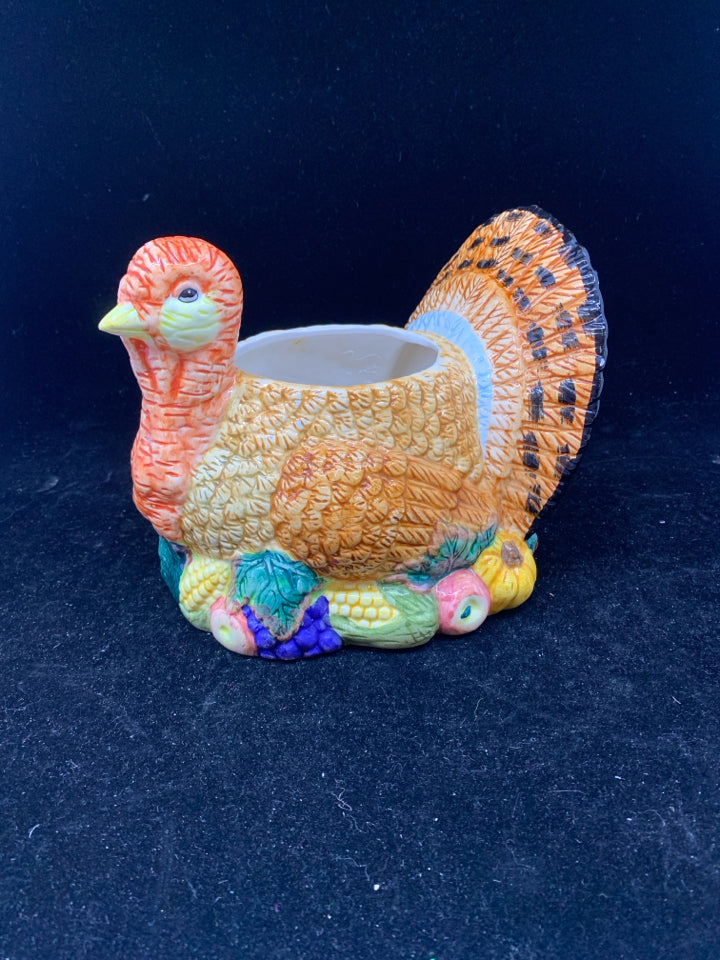 COLORFUL TURKEY BOWL SITTING ON FOOD.