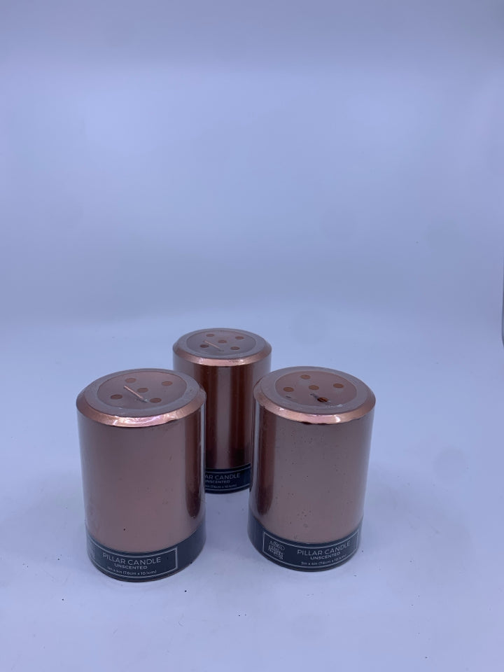 3 NIP ROSE GOLD UNSCENTED PILLAR CANDLES.