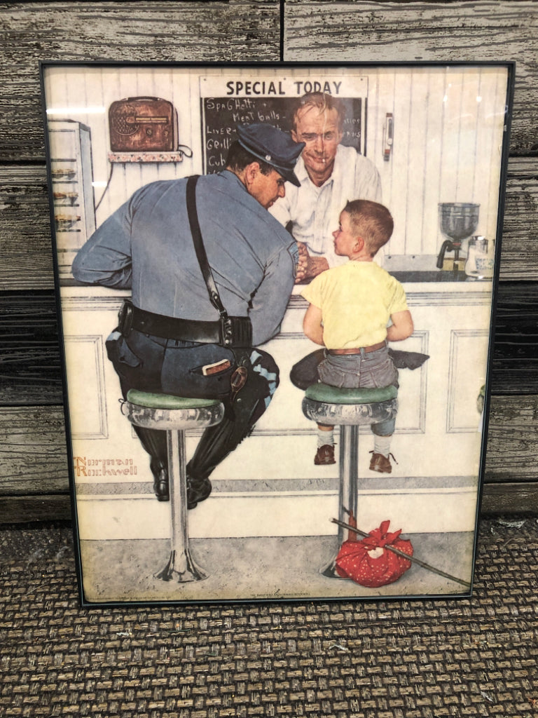 BOY SITTING W COP WALL HANGING.