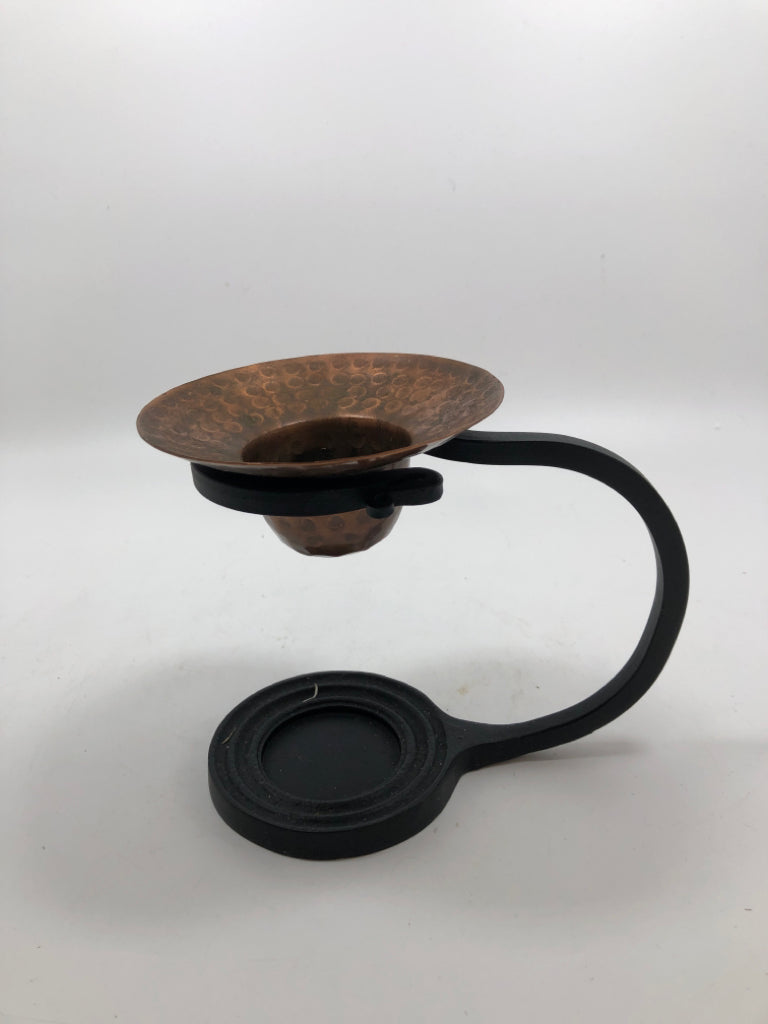 COPPER TEA LIGHT HOLDER IN BLACK METAL STAND.