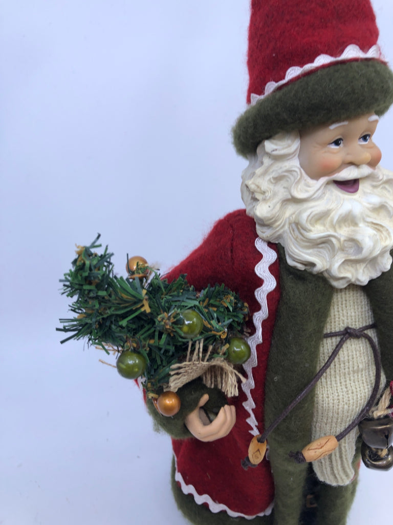 RESIN SANTA W/ RED COAT HOLDING CHRISTMAS TREE.