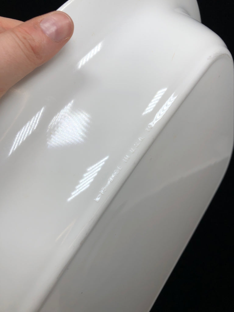 WHITE CASSEROLE DISH IN METAL FRAME.