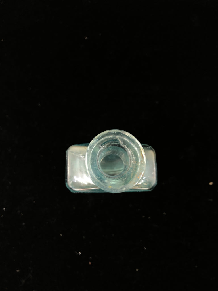 EMPTY LIGHT BLUE GLASS BOTTLE W/ WRITING.