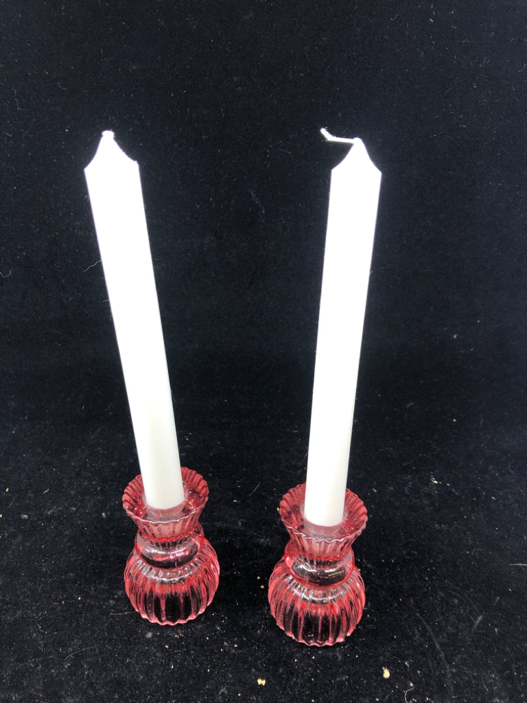2 PINK GLASS PILLAR CANDLE HOLDER W/ WHITE CANDLES.