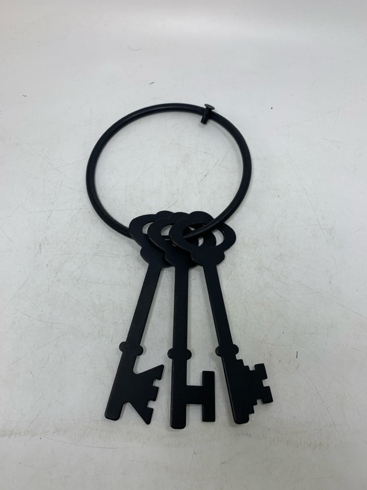 3 FUSED LARGE KEYS ON RING WALL HANGING.