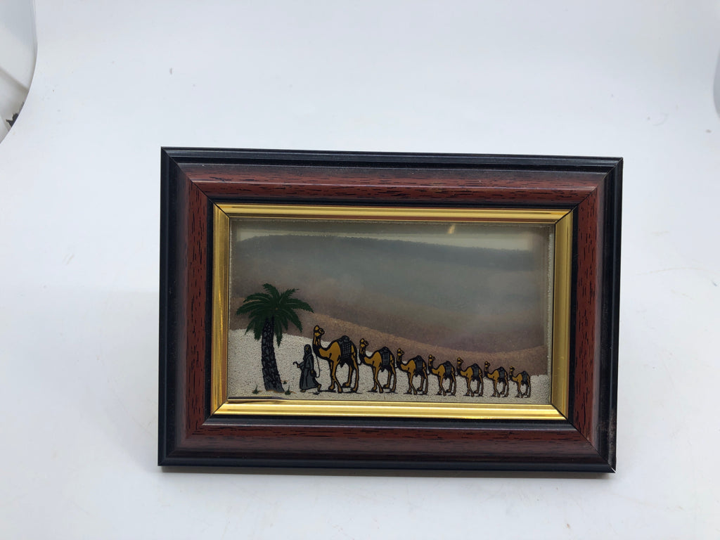 MAN LEADING CAMELS IN FRAME WALL ART.
