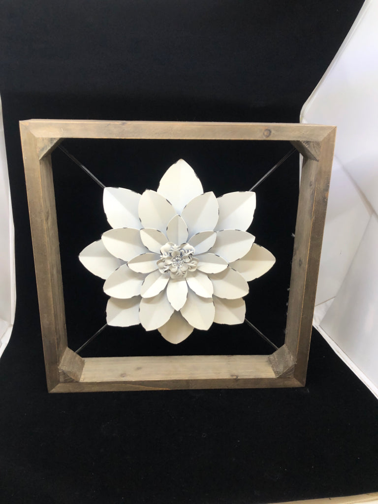 WHITE METAL FLOWER SUSPENDED IN WOOD FRAME.