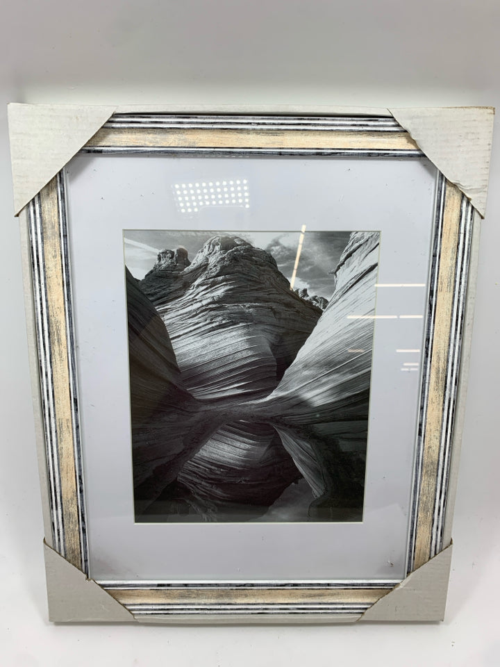 ROCK FORMATION BLACK/WHITE IN WHITE WASHED FRAME.