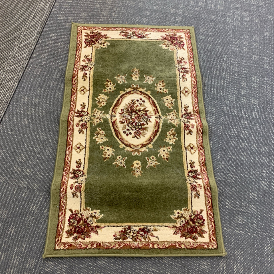 GREEN RUG W/FLORAL MEDALLION DESIGN.