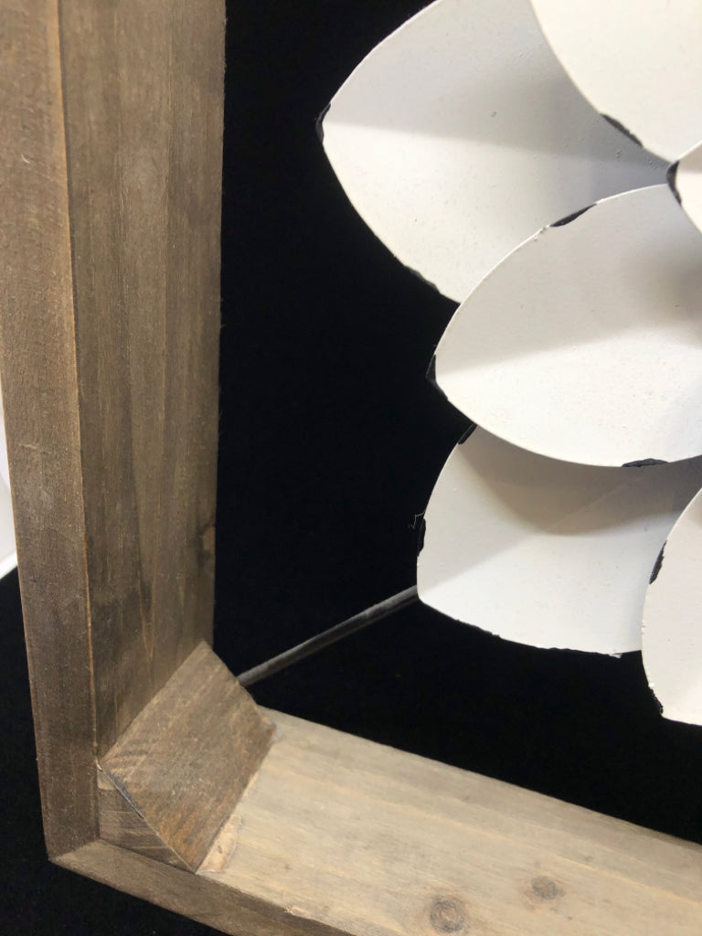 WHITE METAL FLOWER SUSPENDED IN WOOD FRAME.