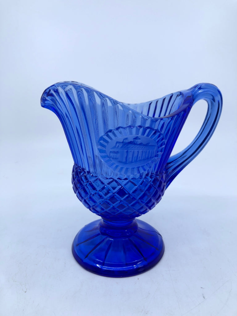 DARK BLUE GLASS FOOTED PITCHER RIBBED W/ EMBOSSED FROSTED HOUSE.