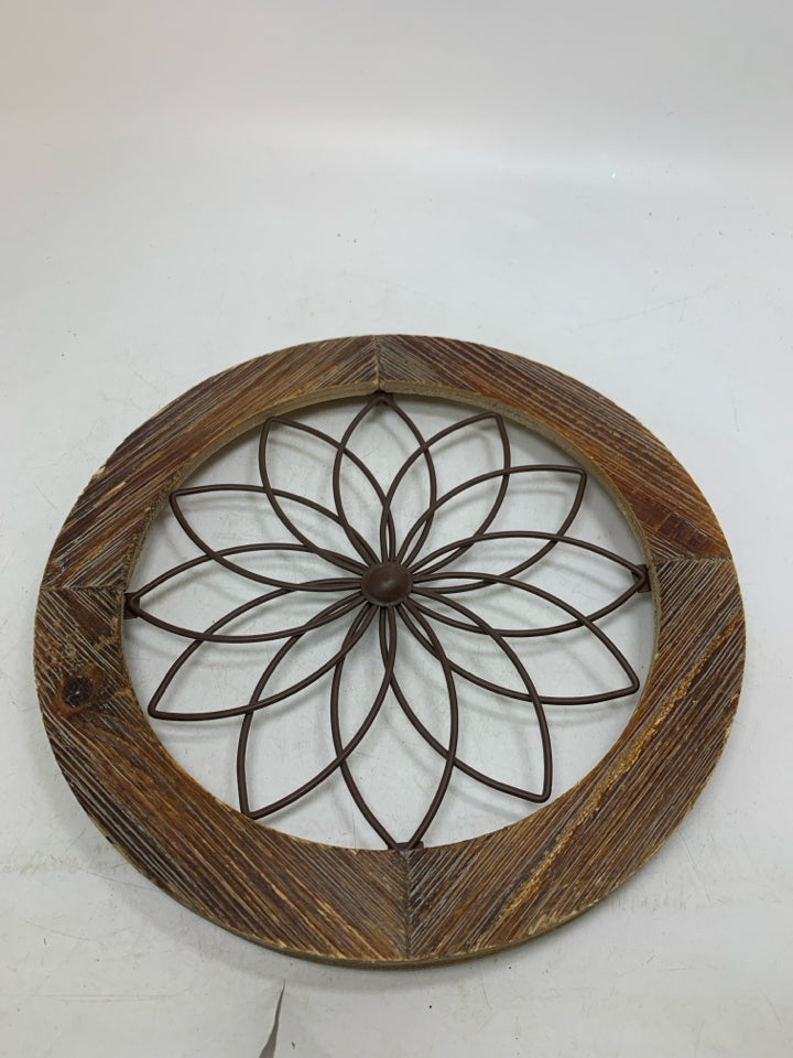 CIRCLE FRAME W/ METAL FLOWER IN CENTER.