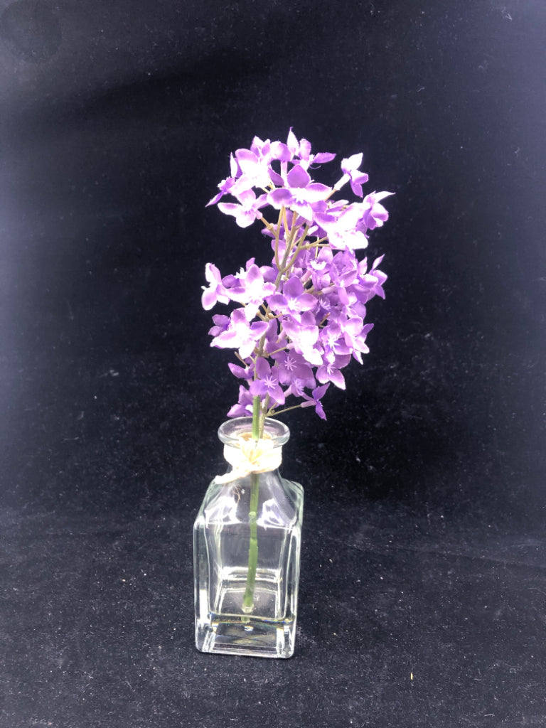 GLASS SQUARE VASE W/ FAUX WATER PURPLE FLOWERS.