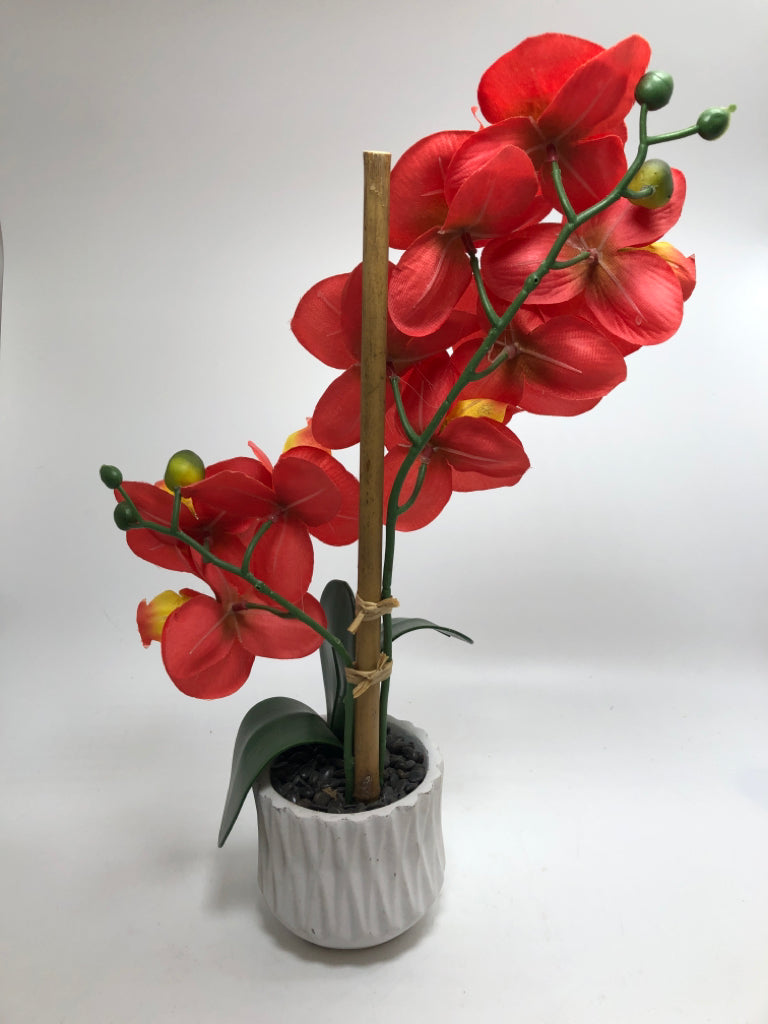 FAUX ORANGE ORCHIDS IN WHITE VASE.