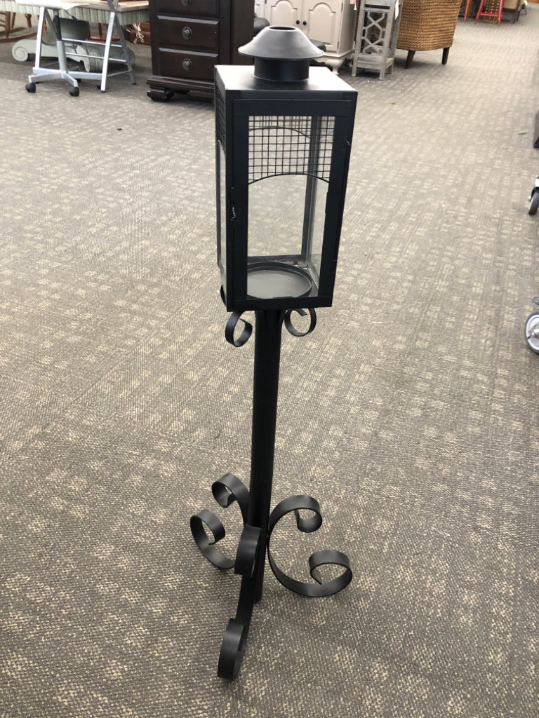 BLACK METAL SCROLL BASE CANDLE LANTERN.