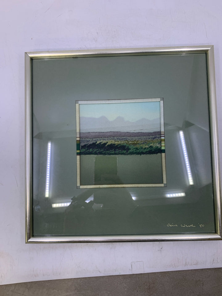 YARN EMBROIDERED GREENS LANDSCAPE IN SILVER FRAME.