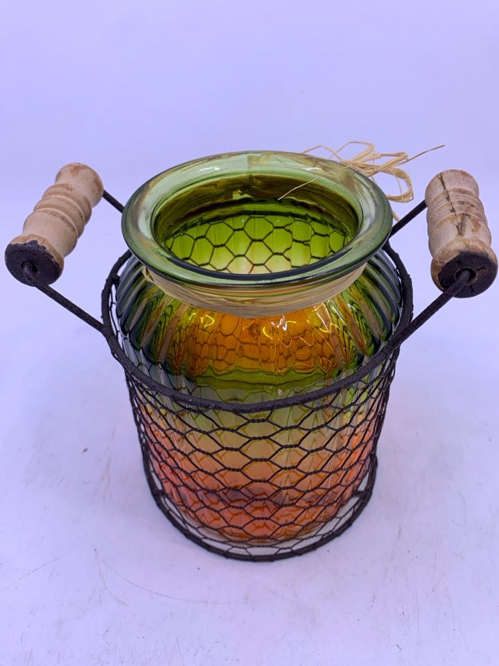 GLASS GREEN/ORANGE RIBBED JAR IN METAL CHICKEN WIRE INSERT CANDLE HOLDER.