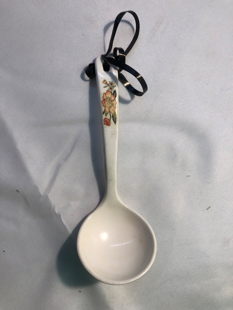 WHITE SERVING SPOON W/ ORANGE FLOWER ON HANDLE.