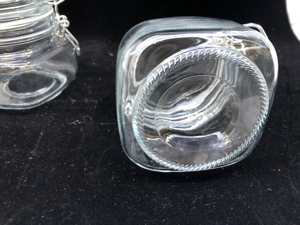 2 SHORT CLEAR GLASS CANISTERS W/ METAL CLASP LID.