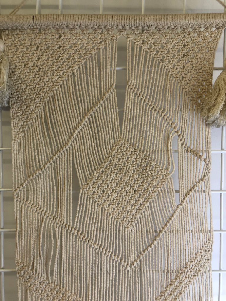MACRAME WALL HANGING ON DOWEL W/ LARGE TASSELS.
