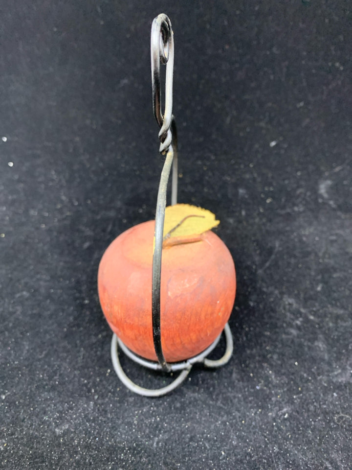 RED PRIMITIVE APPLE ON STAND.
