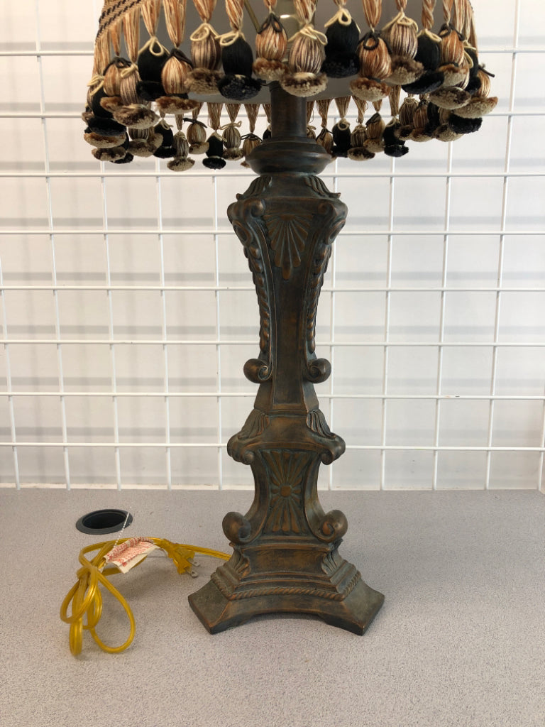 HEAVY LAMP W/SCROLL DISTRESSED BASE AND FABRIC SHADE W/TASSELS.