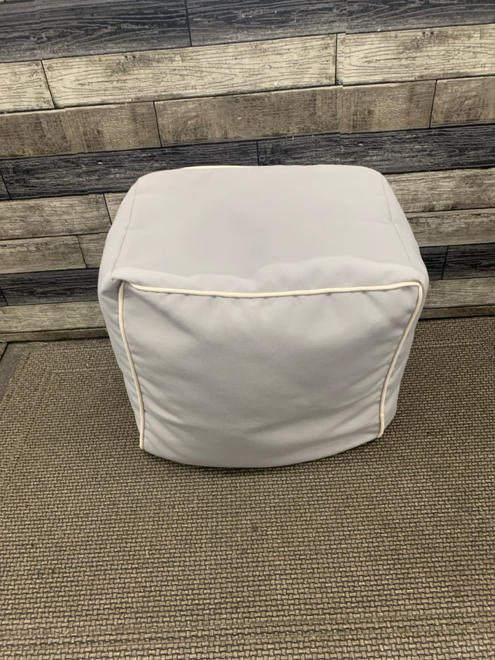 GREY CUBE OTTOMAN W WHITE ACCENT.
