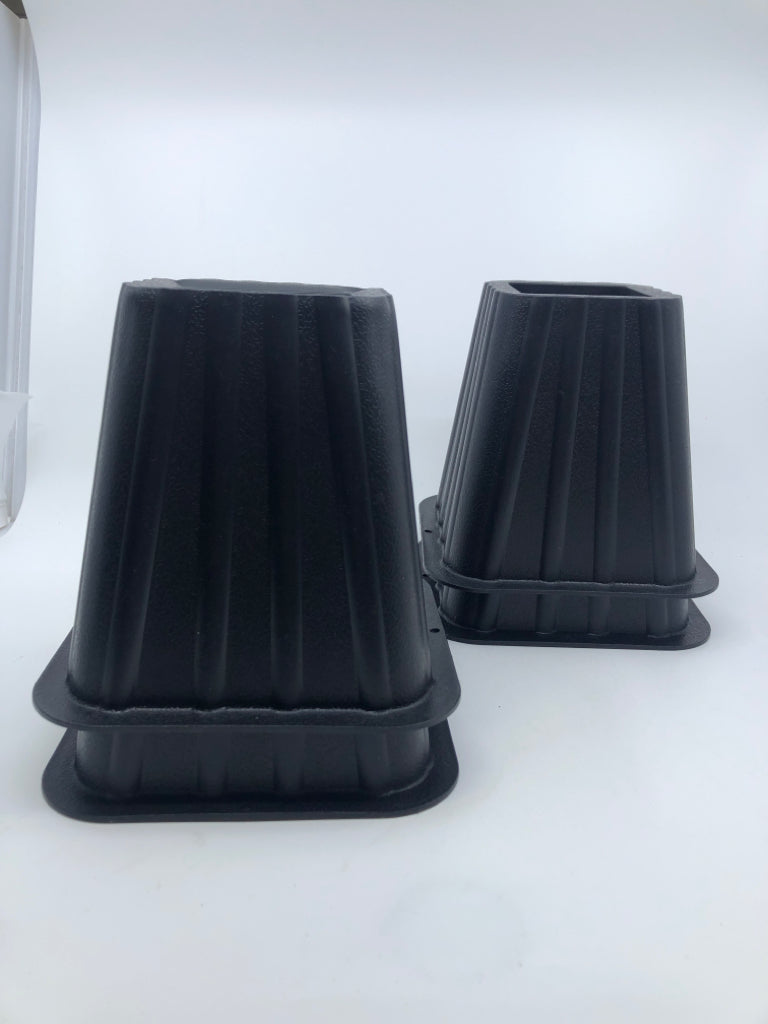 4 BLACK PLASTIC BED RISERS.