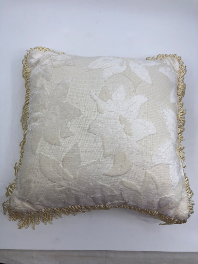 WHITE SMALL PILLOW W/ EMBOSSED FLOWERS FRINGE ON EDGES.