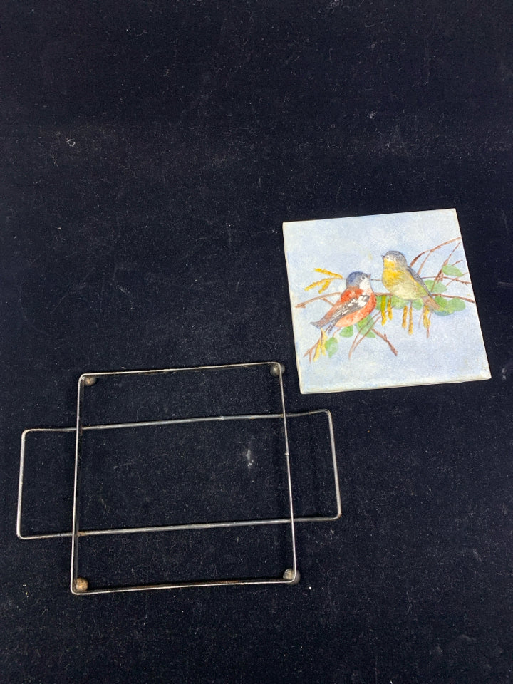 BIRD TRIVET IN A METAL STAND.