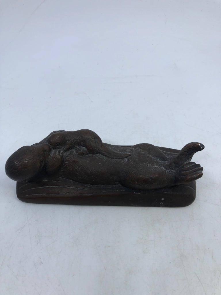 BROWN OTTER HOLDING BABY SWIMMING.