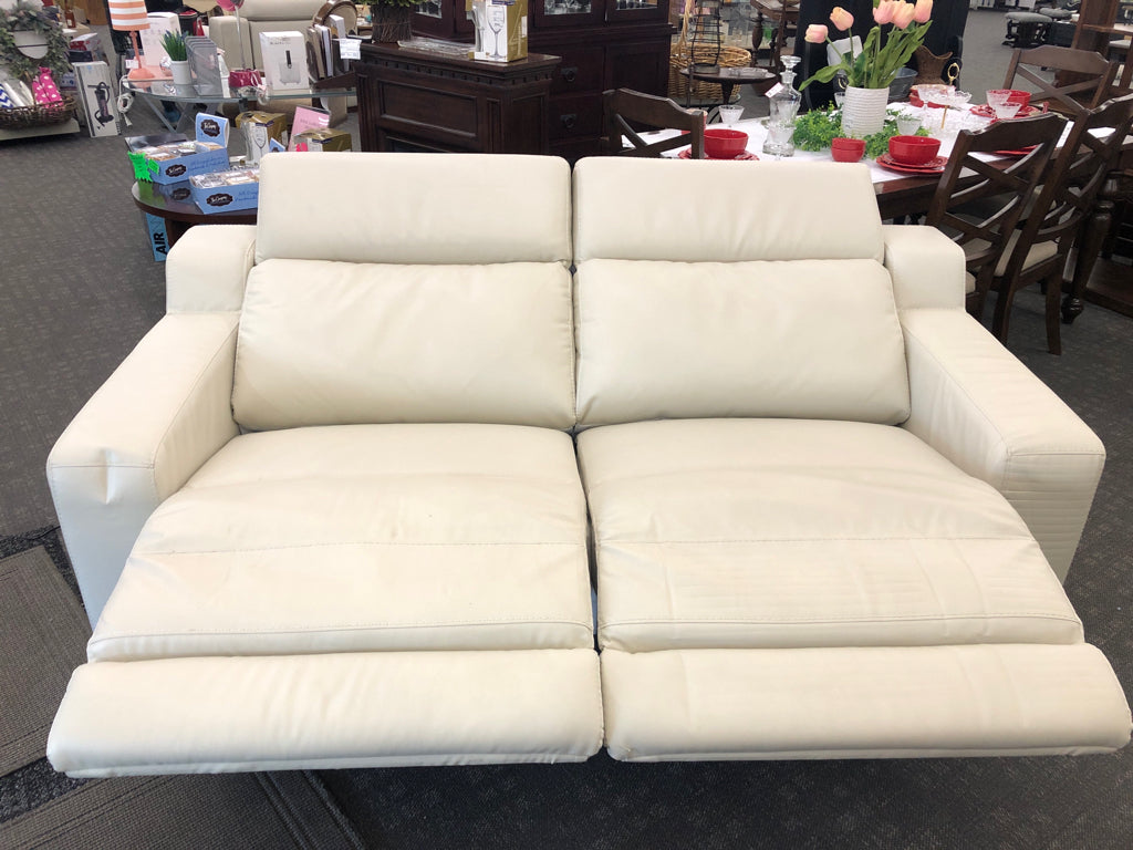 WHITE FAUX LEATHER RECLINING LOVE SEAT.