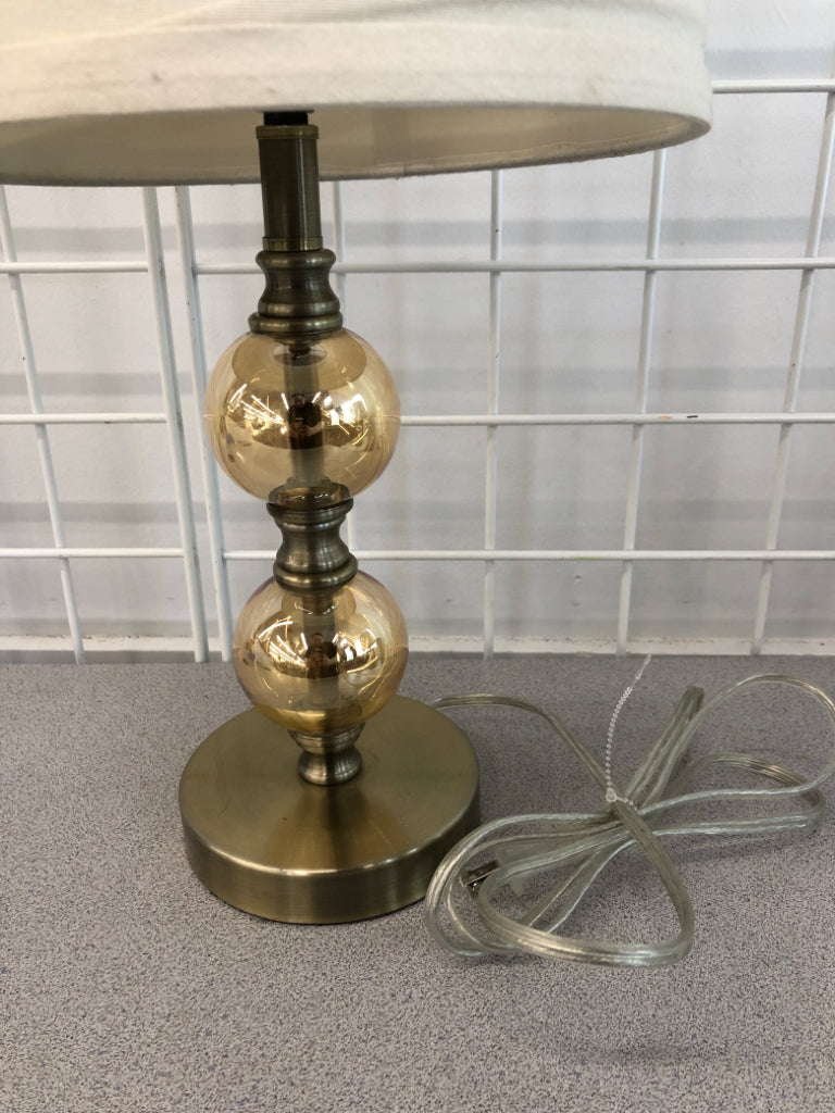 GOLD CLEAR GLASS LAMP W/FOLDED CREAM SHADE.