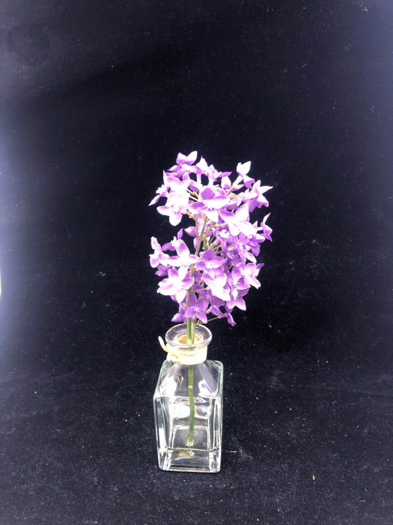 GLASS SQUARE VASE W/ FAUX WATER PURPLE FLOWERS.