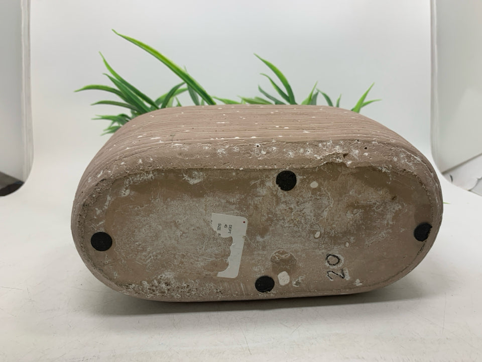 FAUX GRASS IN PLANTER.