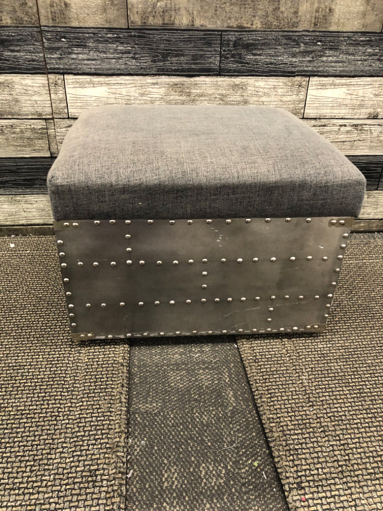 SMALL GREY STUDDED OTTOMAN W METAL HANDLES AND STORAGE.