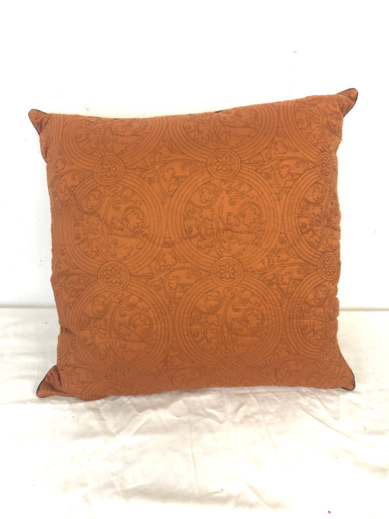 BURNT ORANGE PILLOW W/ STITCHED PATTERN.