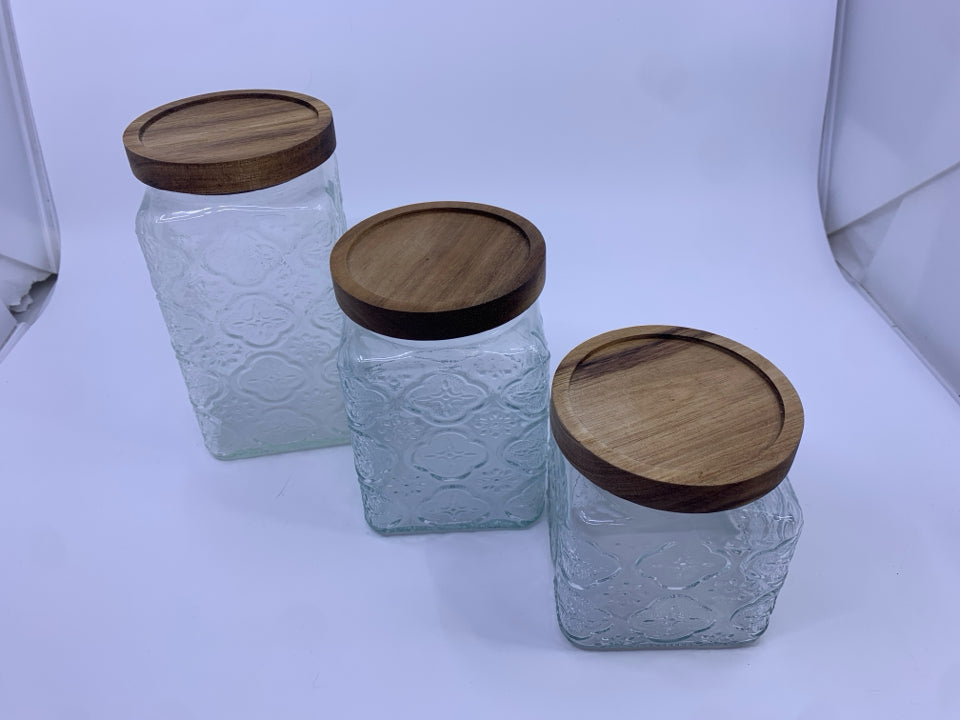 3 EMBOSSED CANISTERS W WOOD TOPS.