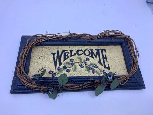 BLUE WOOD WELCOME SIGN WITH TWIG AND BERRY ACCENTS.