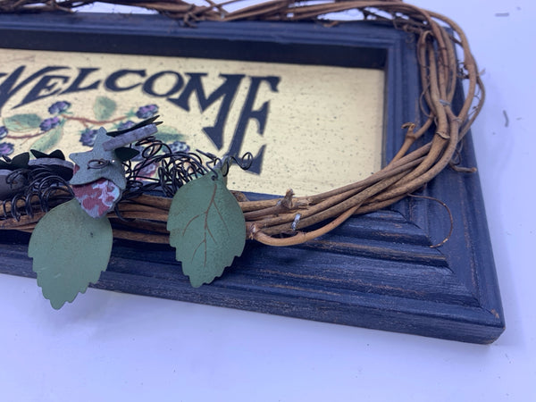 BLUE WOOD WELCOME SIGN WITH TWIG AND BERRY ACCENTS.